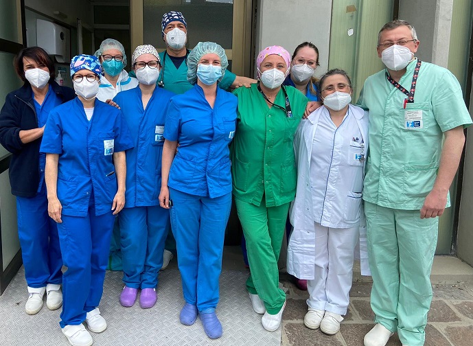 Nella foto ildottor Cipani con équipe terapia intensiva Ospedale di Pescia, un gruppo di persone, medici, infermieri e oss in divisa, all'esterno davanti una porta. Tutti con la mascherina e in divisa.